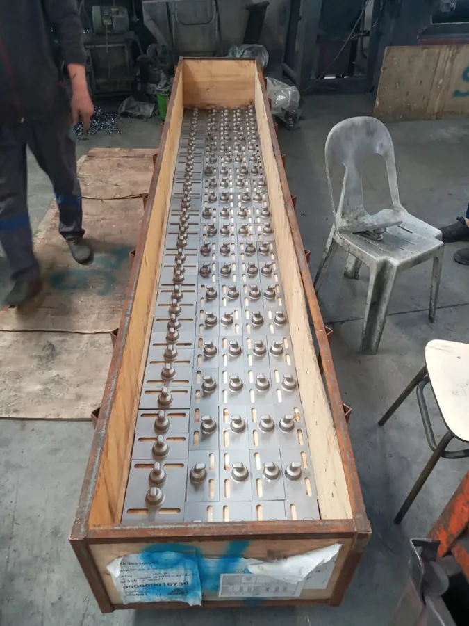 Crate of machined roller hooks for a mining conveyor system