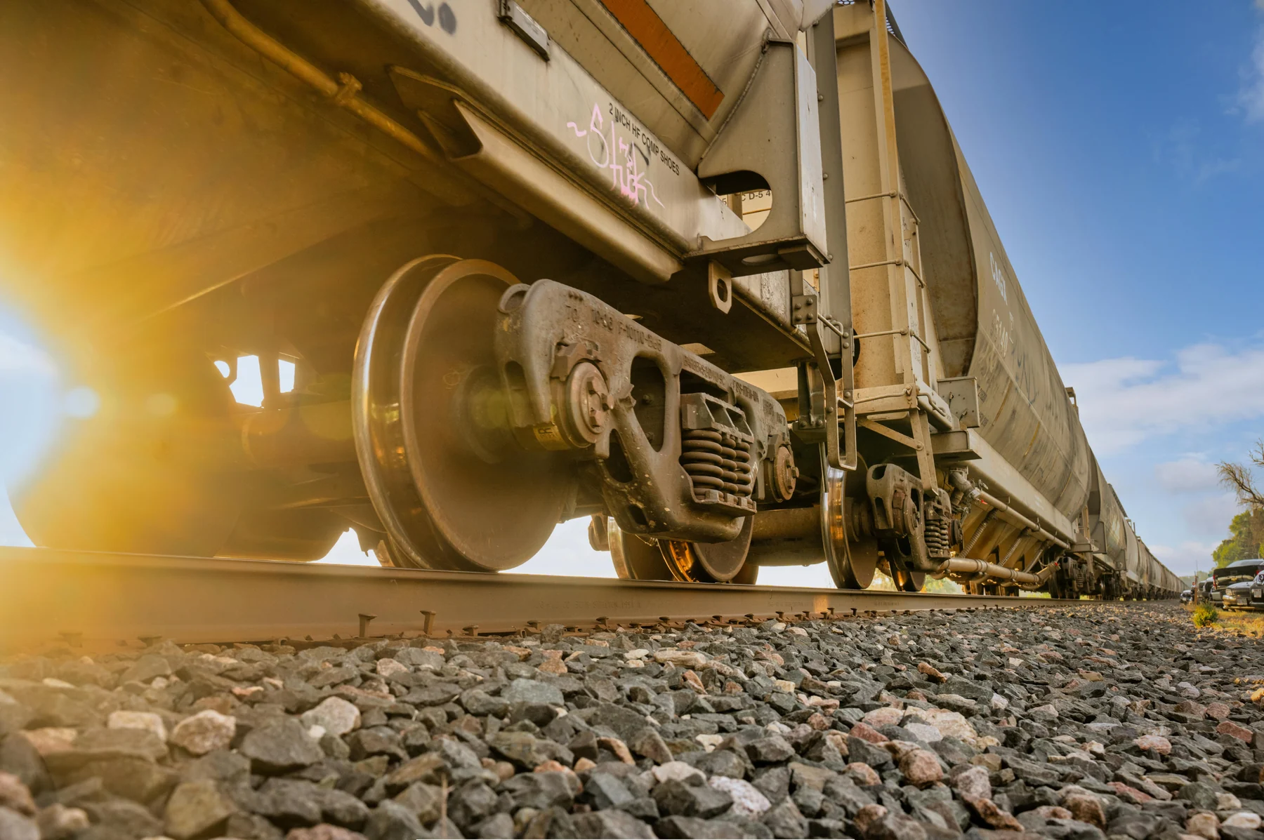 Freight wagon standing on ballasted track in low sun